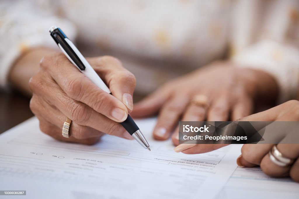 Shot of a woman going over paperwork with her elderly mother at home A retirement plan you can bet your life on Will - Legal Document Stock Photo