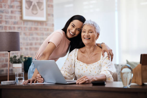 strzał młodej kobiety za pomocą laptopa ze starszą matką podczas przechodzenia przez finanse w domu - pension senior adult grandparent planning zdjęcia i obrazy z banku zdjęć