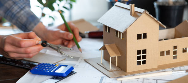 istock Workplace of architect - construction drawings, scale model and tools. Modern house design, real estate concept. 1330031787
