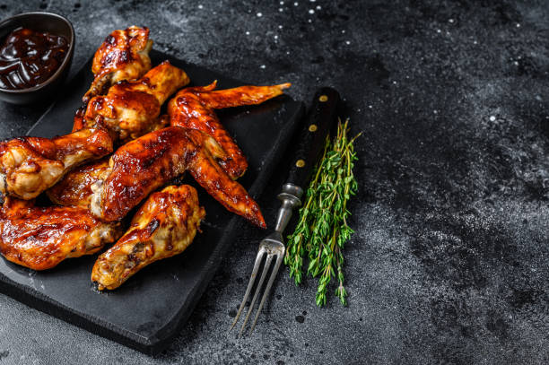 istock Hot Barbecue chicken wings with sauce bbq. Black background. Top view. Copy space 1330033085