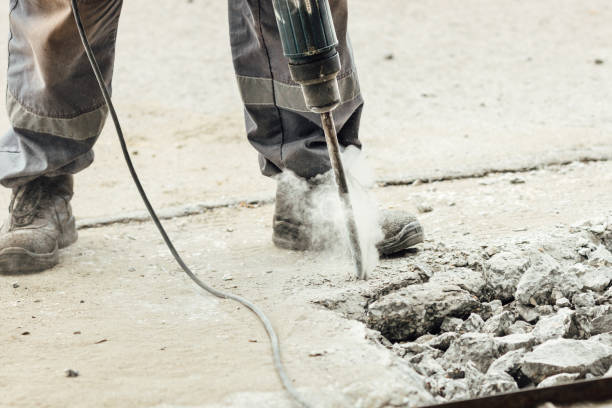 istock A worker repairs the road surface with a jackhammer on a summer day. Construction works on the road 1330033434