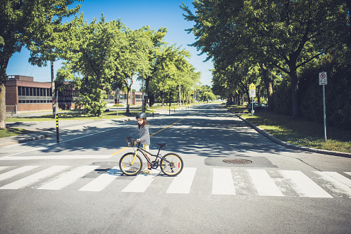 Una niña cruzando la carretera con su bicicleta photo