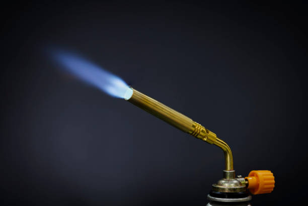 istock Blue flame from a gas torch burner on black background 1330040330