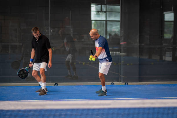 모니터 교육 파델 클래스 남자, 그의 학생 - 트레이너는 실내 테니스 코트에서 파델을 재생하는 방법을 소년을 가르친다 - racket ball indoors competition 뉴스 사진 이미지