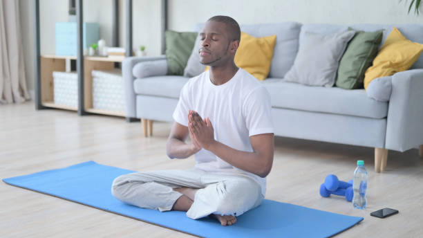 istock Meditating African Man  Sitting on Yoga Mat 1330042793