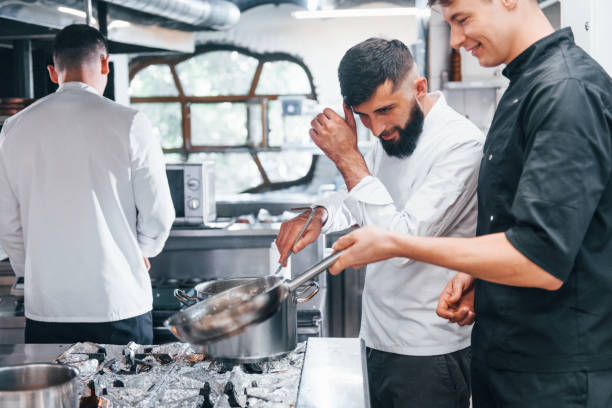 istock People in white uniform cooking food at kitchen together. Busy day at work 1330043314