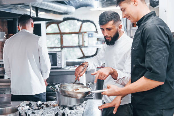 istock People in white uniform cooking food at kitchen together. Busy day at work 1330043399