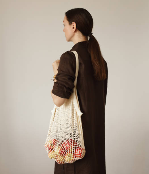 istock Woman holding mesh bag with apples 1330045136