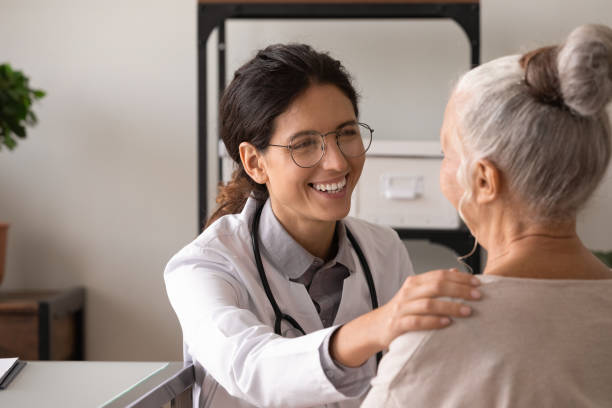 istock Smiling doctor support old lady patient in clinic 1330045911