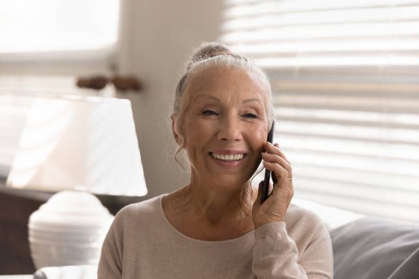 istock Smiling mature woman talk on cellphone gadget 1330045922