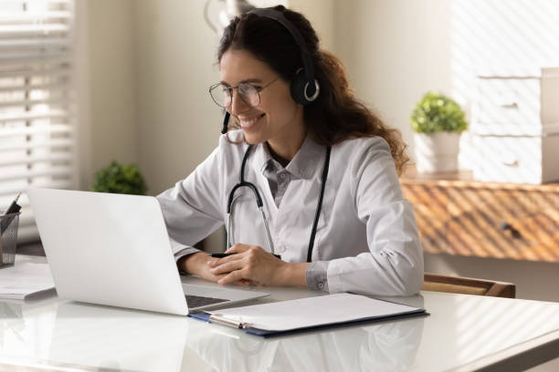 istock Smiling female doctor have webcam digital consultation on computer 1330045932