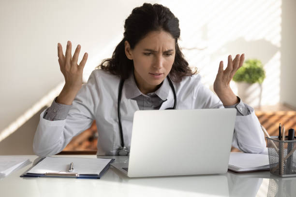 une femme médecin en colère a des problèmes à travailler sur ordinateur - problems healthcare and medicine failure doctor photos et images de collection