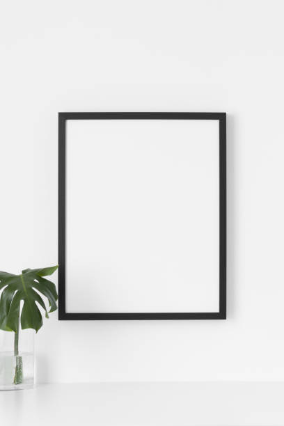 istock Black frame mockup on the wall with a  monstera leaf in a glass vase. 1330047957