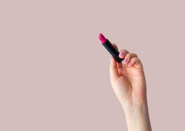 istock Woman holding bright lipstick on color background 1330048977