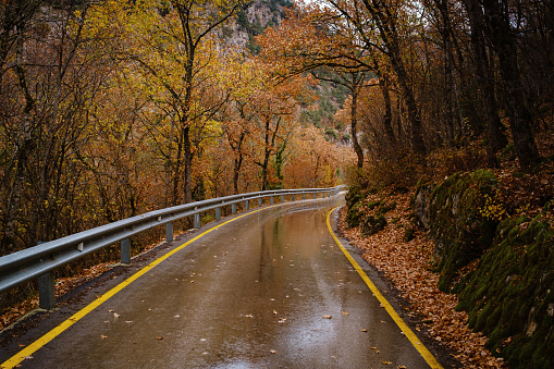 Wet road with turns at rain in Norway. Car driving safety concept.