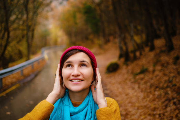 woman in a hat and a sweater with a backpack on her back fun autumn landscape river. High quality photo
