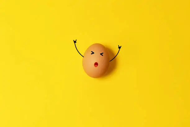 Photo of Chicken egg on yellow background. Natural healthy organic food. Top view, flat lay, copy space.