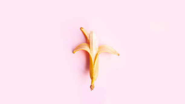letnia koncepcja witaminy. płaska kompozycja słodkiego otwartego banana na różowym tle z kopiuj miejsca na tekst. - single object sensuality education isolated zdjęcia i obrazy z banku zdjęć