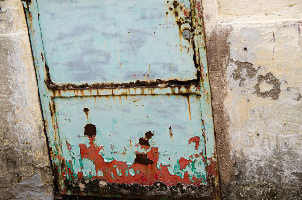 istock wall with paint peeling off and rusty metal door 1330053942