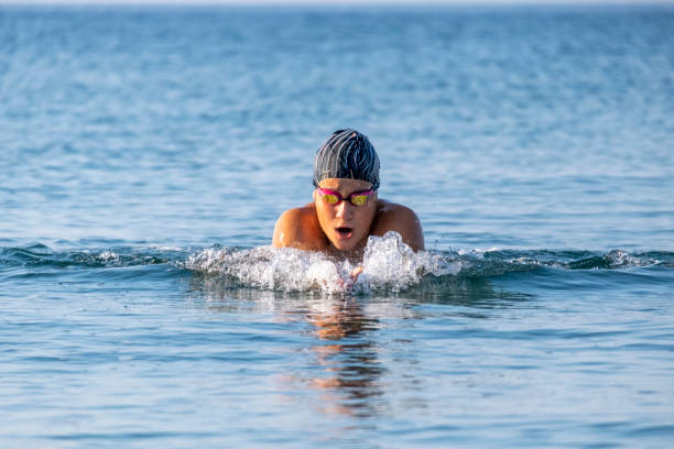 istock Professional swimmer exercising in blue sea and taking deep breath 1330054647