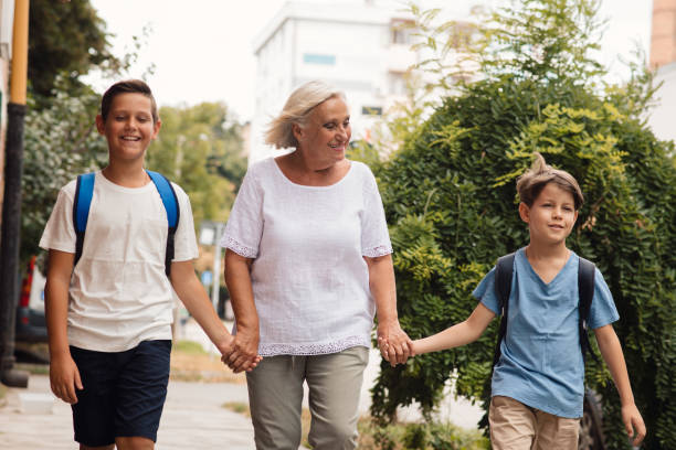 istock Granny taking grandkids to school. 1330059865