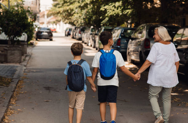 istock Two boys and their granny are going home from school. 1330060132