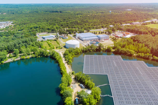 Panels floating on water with floating solar panels in a blue pond under the sunlight Panorama view on panels floating on water with floating solar panels in a blue pond under the sunlight. floating electric generator stock pictures, royalty-free photos & images