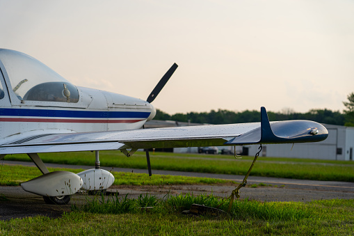 Small airplane parked on a runway with door open