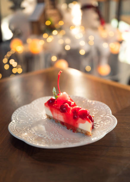 istock Strawberry cheesecake with biscuit layer, cherry and jam in white plate on wooden table 1330071008