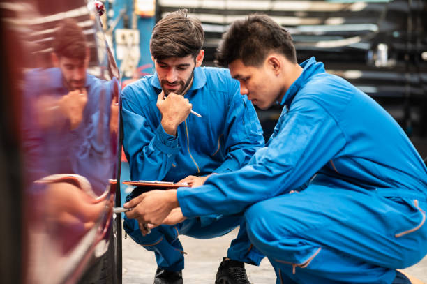 istock Two professional look technician inspecting car tire and wheel by using check list in modern car service shop. Automotive business or car repair concept. 1330071910