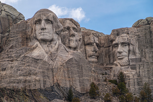 Black Hills, Keystone, SD, USA - May 31, 2008: Mount Rushmore. Near view of the famous sculpture of 4 presidents. Gray granite under blue cloudscape.