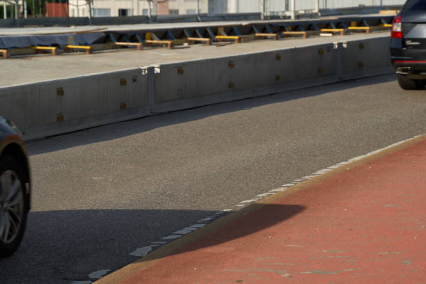 istock Construction site on a bridge, concrete barrier separates the road and the bike path safely. Parts of cars. 1330076738