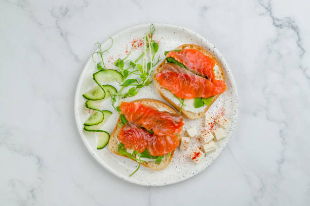 istock Bruschetta with salmon and cheese on white plate on marble table top view 1330077949