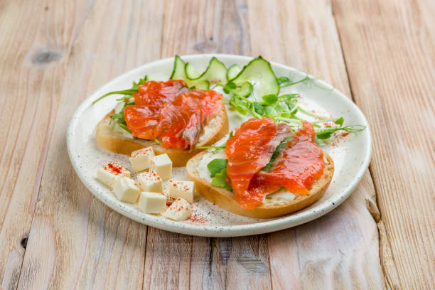 istock Bruschetta with salmon and cheese on white plate on wooden table 1330077968