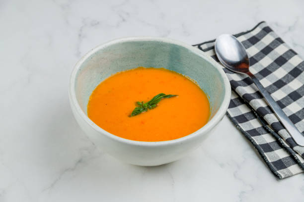 istock Soup cream of tomato with basyl on white marble table 1330077986