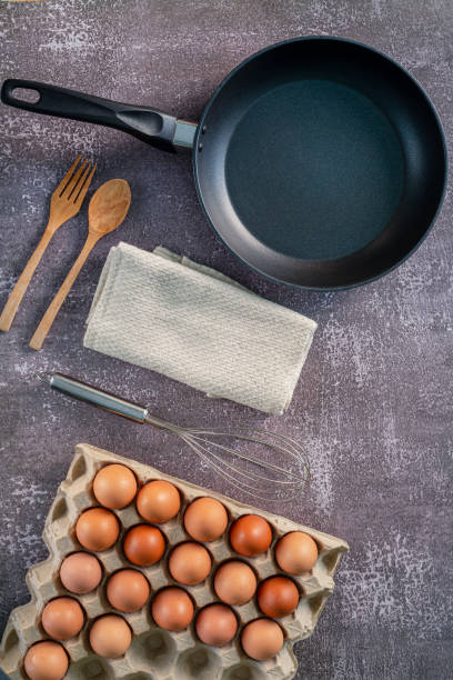Still life with eggs and pan on wooden table, top view,Animal,Bread,Breakfast,Cholesterol,Circle,Close-up,Cooked,Cooking,Cooking Oil,Cooking Pan,Cutting Board,Drink,Egg,Egg Yolk,Farm,Food,Freshness,Fr