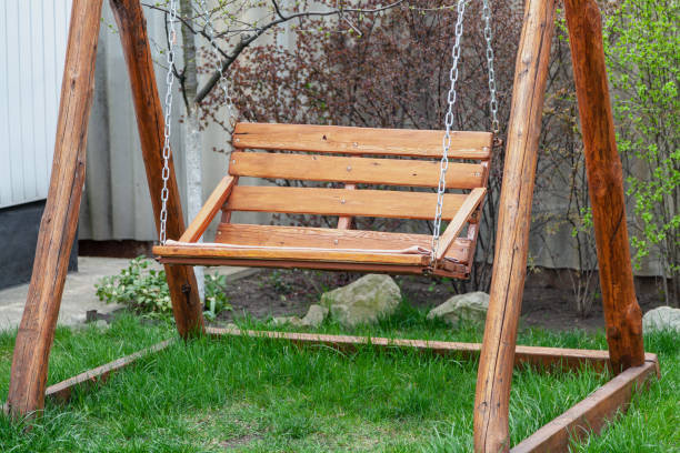 istock Wooden swing on chains stands on green grass 1330083196