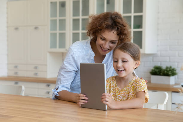 istock Happy young mother using digital computer tablet with kid daughter. 1330084400