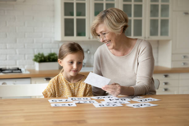 piccola bambina in età prescolare che impara la matematica con la nonna. - brain case foto e immagini stock