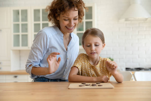 istock Young 35s mother playing checkers with small daughter. 1330084420
