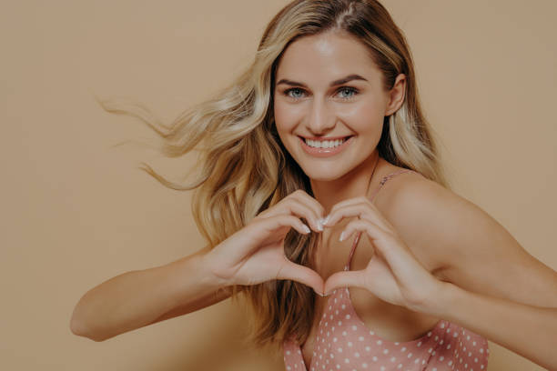 istock Blonde woman making heart shape with her hands 1330084948