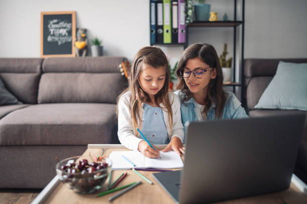 istock Mother helping daughter with her homework at home 1330086021