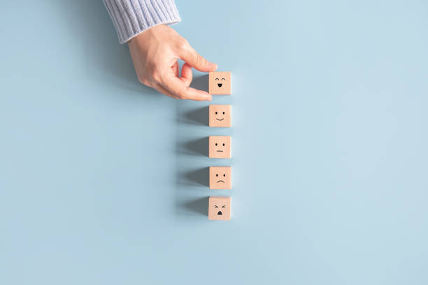 istock Customer service evaluation and satisfaction survey concepts. The client's hand picked the happy face smile face icon symbol on wooden cube. 1330088323