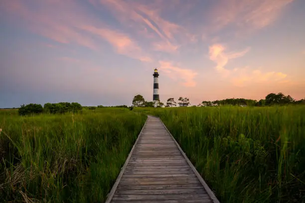 Path leading toward Bodie Island Lighthouse during a sunset in North Carolina