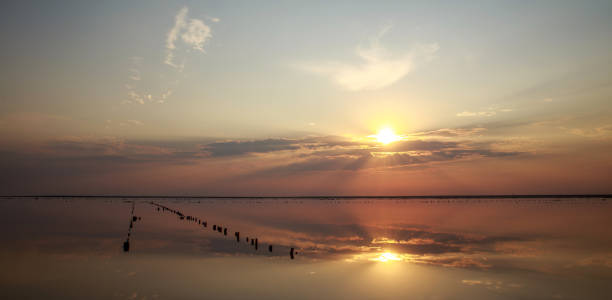 istock Dreamy and dramatic colorful sunset sky over calm water surface with cloud reflections 1330094738