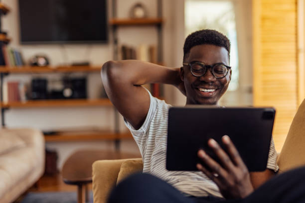 istock African man, smiling at his old albums. 1330098175
