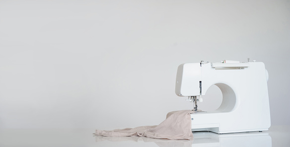 Nueva máquina de coser sobre fondo gris. photo
