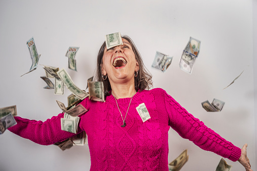 Woman celebrates under a rain of 100 dollar bills