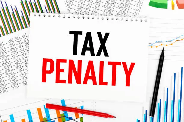 Photo of TAX PENALTY on notebook, chart, graph. Business concept. Flat lay.