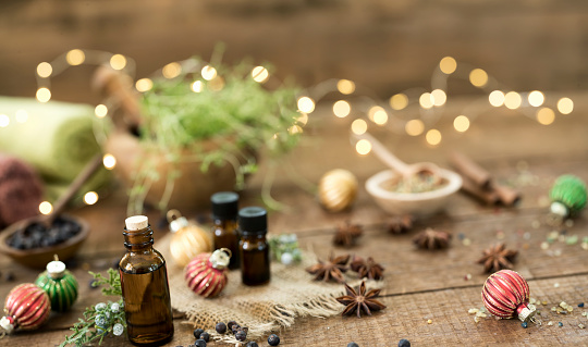 Holiday essential oils against an all nature wood background.